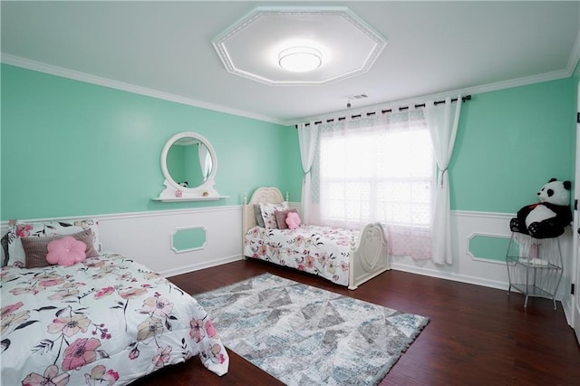 bedroom featuring crown molding, baseboards, visible vents, and wood finished floors
