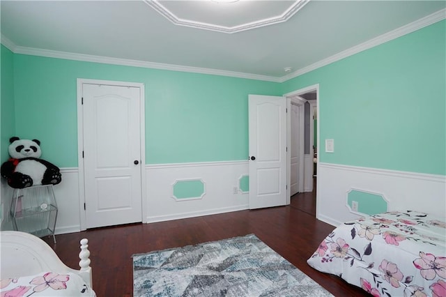 bedroom featuring crown molding, wainscoting, and wood finished floors