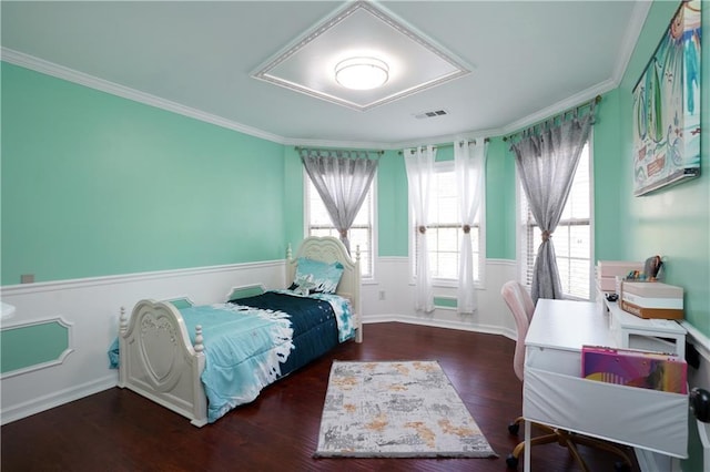 bedroom with ornamental molding and wood finished floors