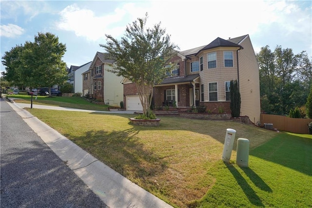traditional home with brick siding, a garage, fence, and a front lawn