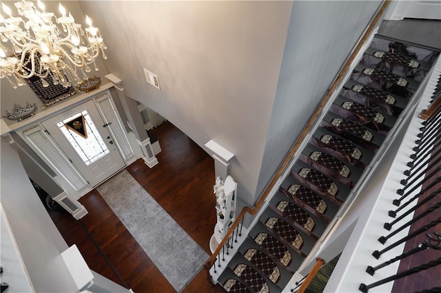 entryway featuring a towering ceiling, visible vents, dark wood-style floors, and a chandelier