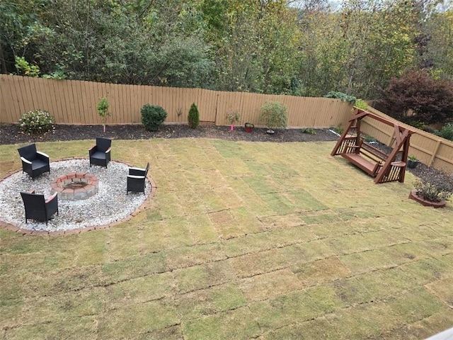 view of yard featuring a patio, a fenced backyard, and an outdoor fire pit