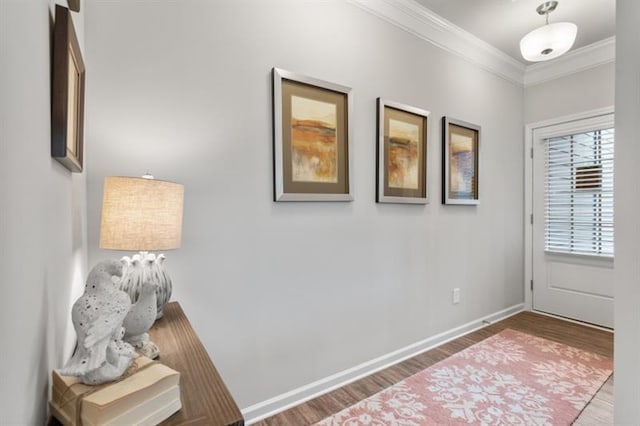 foyer entrance with ornamental molding, wood finished floors, and baseboards
