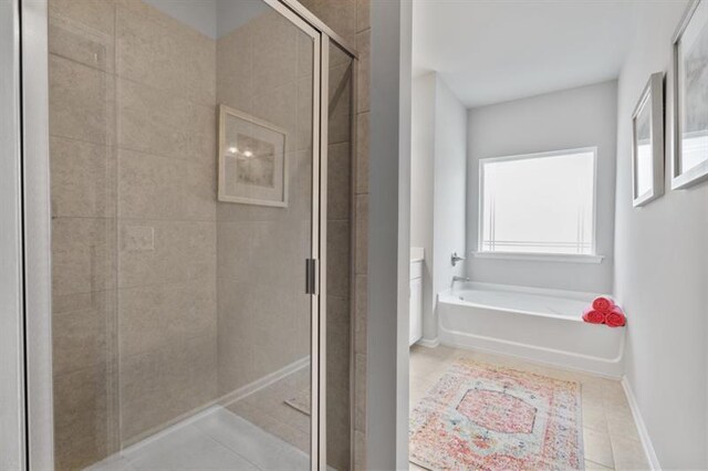 full bath with tile patterned floors, a shower stall, a bath, and baseboards