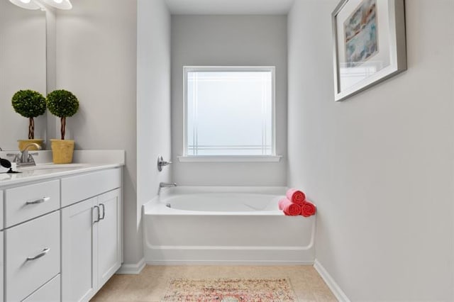 full bath featuring vanity, a garden tub, baseboards, and tile patterned floors