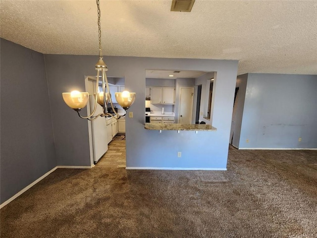 interior space featuring a textured ceiling, carpet flooring, and a chandelier