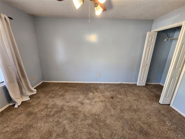 unfurnished bedroom featuring a textured ceiling, ceiling fan, a closet, and dark carpet