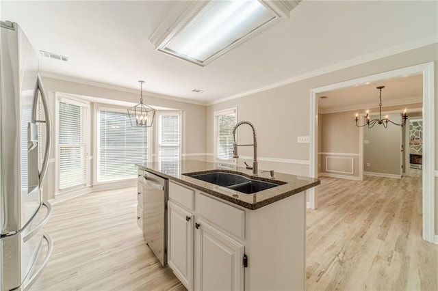 4120 Grady Smith Rd, Loganville, GA 30052 - kitchen featuring stainless steel appliances, a chandelier, ornamental molding, a center island with sink, and light wood finished floors