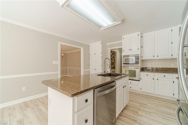 4120 Grady Smith Rd, Loganville, GA 30052 - kitchen with appliances with stainless steel finishes, decorative backsplash, light wood finished floors, dark stone countertops, and white cabinets