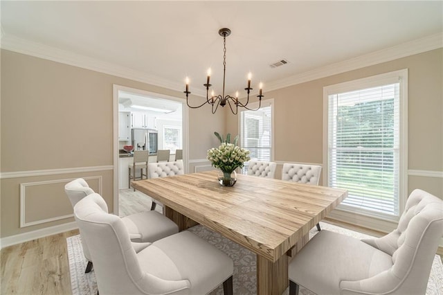 4120 Grady Smith Rd, Loganville, GA 30052 - dining area featuring a chandelier, ornamental molding, and light wood-style flooring