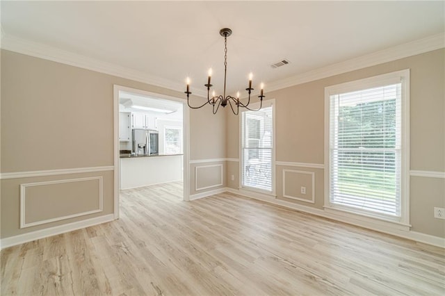 4120 Grady Smith Rd, Loganville, GA 30052 - unfurnished room with a chandelier, light wood-style floors, healthy amount of natural light, crown molding, and a wainscoted wall