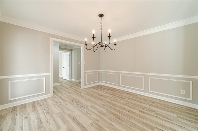 4120 Grady Smith Rd, Loganville, GA 30052 - spare room with a chandelier, light wood-style flooring, crown molding, a wainscoted wall, and a decorative wall