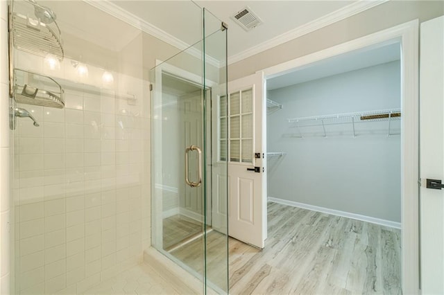 4120 Grady Smith Rd, Loganville, GA 30052 - bathroom featuring a shower stall, wood finished floors, ornamental molding, and a walk in closet
