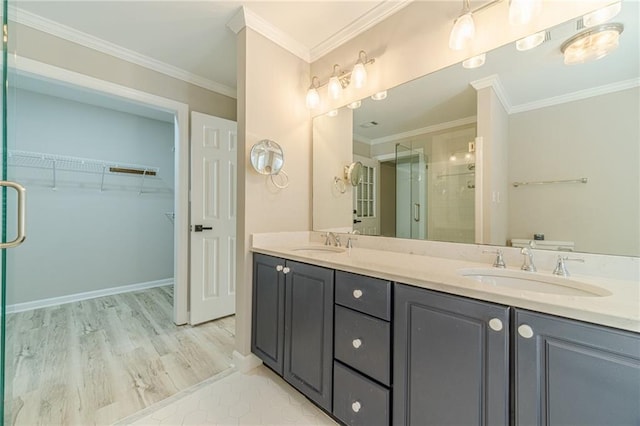 4120 Grady Smith Rd, Loganville, GA 30052 - bathroom featuring a shower stall, double vanity, a spacious closet, ornamental molding, and wood finished floors