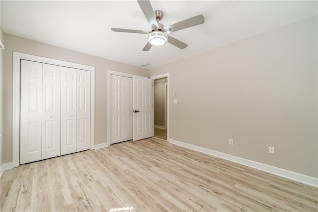 4120 Grady Smith Rd, Loganville, GA 30052 - unfurnished bedroom featuring two closets, light wood-style floors, and ceiling fan