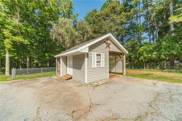 4120 Grady Smith Rd, Loganville, GA 30052 - view of front facade featuring an outdoor structure, view of wooded area, and asphalt driveway