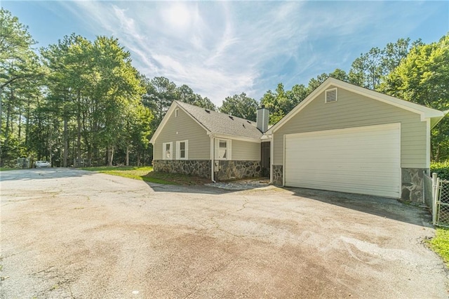 4120 Grady Smith Rd, Loganville, GA 30052 - view of front of home with stone siding, an outdoor structure, asphalt driveway, and a chimney