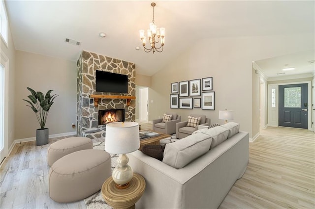 4120 Grady Smith Rd, Loganville, GA 30052 - living room featuring light wood-type flooring, a chandelier, lofted ceiling, and a fireplace