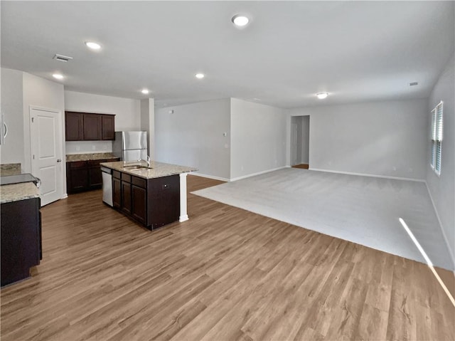 kitchen with stainless steel appliances, light hardwood / wood-style flooring, a center island with sink, and sink