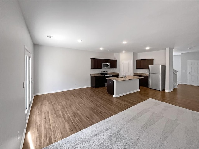 kitchen featuring a kitchen island with sink, dark wood-type flooring, stainless steel appliances, and sink