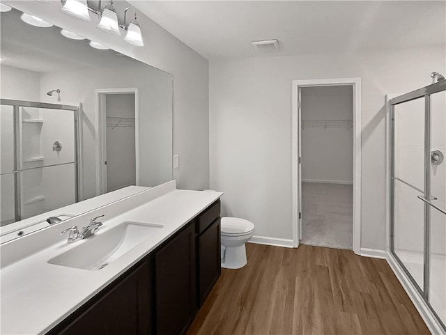 bathroom with vanity, toilet, wood-type flooring, and walk in shower