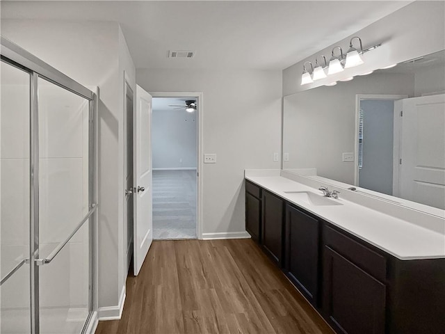 bathroom featuring ceiling fan, vanity, wood-type flooring, and an enclosed shower