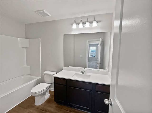 full bathroom featuring hardwood / wood-style flooring, vanity, shower / bathtub combination, and toilet