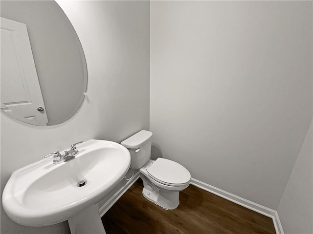 bathroom with hardwood / wood-style floors, toilet, and sink