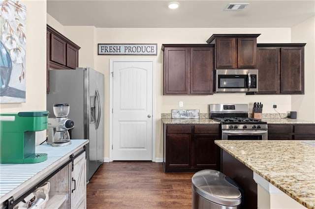 kitchen with dark brown cabinetry, dark wood-style floors, visible vents, and appliances with stainless steel finishes