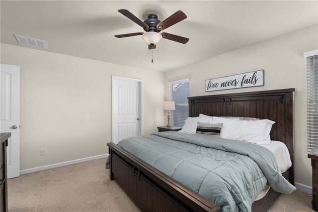bedroom with light colored carpet, visible vents, baseboards, and a ceiling fan