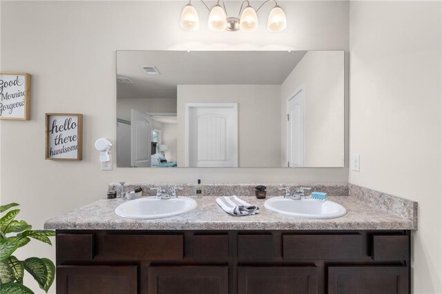 full bath featuring double vanity, visible vents, and a sink