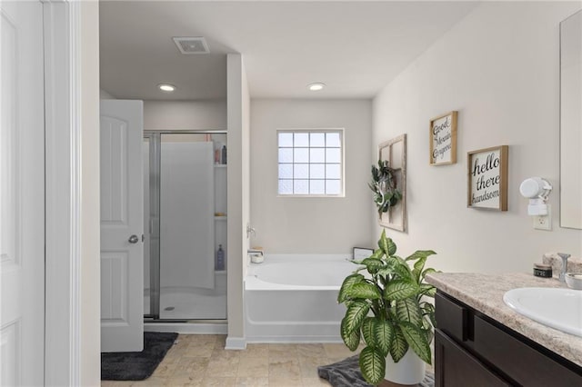 full bathroom with vanity, a bath, a stall shower, and visible vents