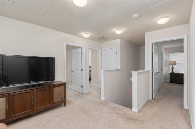 interior space featuring an upstairs landing, baseboards, and light colored carpet