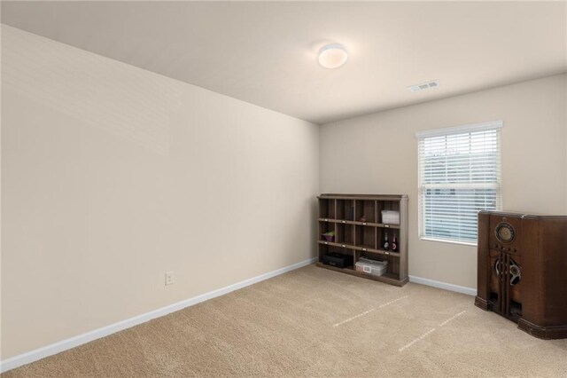 interior space featuring baseboards, visible vents, and carpet