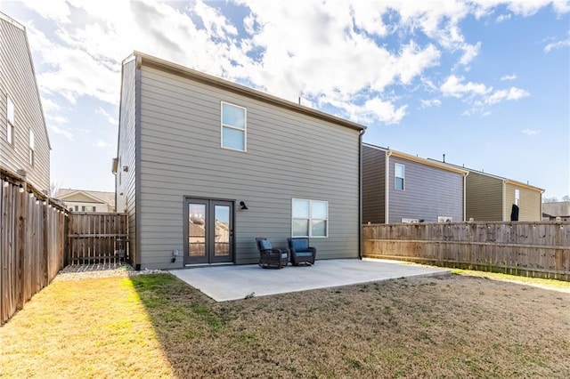 rear view of property featuring french doors, a fenced backyard, a yard, and a patio area