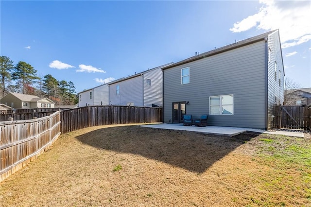 back of property with a fenced backyard, a lawn, and a patio