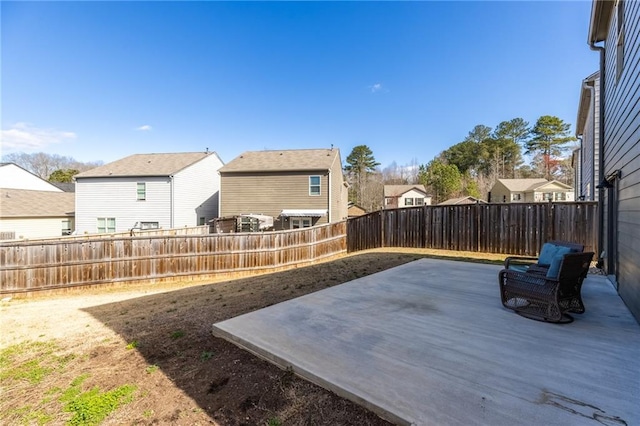 view of yard featuring a fenced backyard, a residential view, and a patio