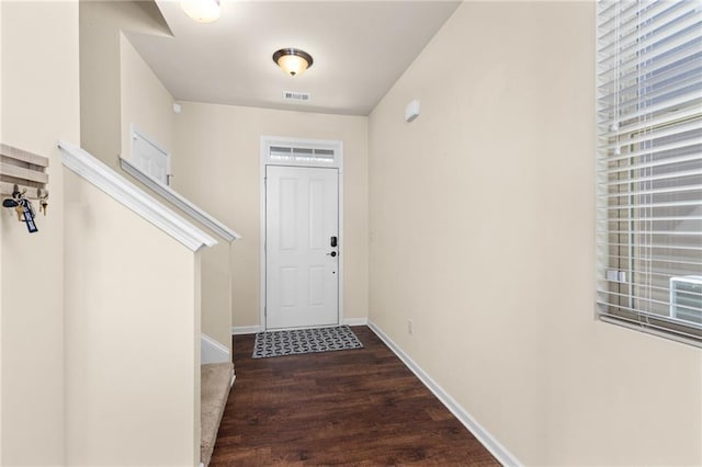 doorway featuring baseboards, visible vents, and wood finished floors