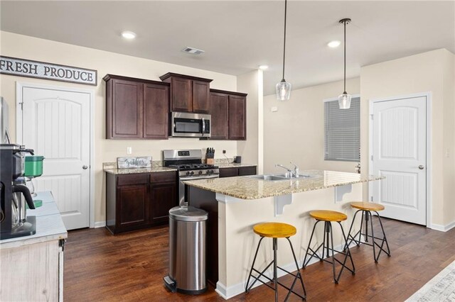 kitchen with a sink, stainless steel appliances, dark wood-type flooring, and visible vents
