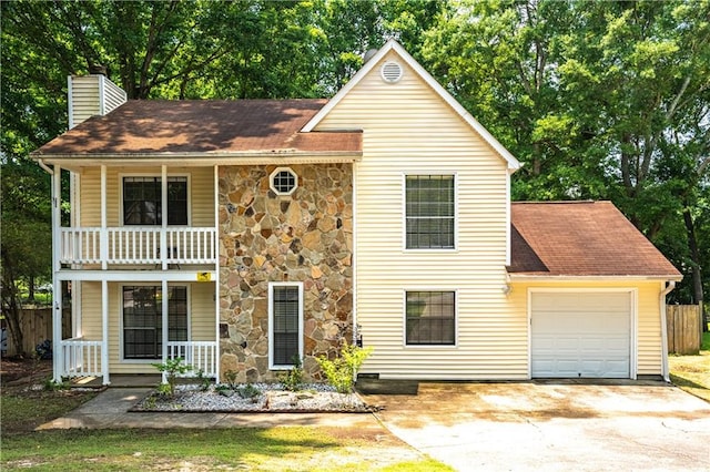 2568 Redfield Dr, Norcross, GA 30071 - traditional-style house with a balcony, a chimney, covered porch, a garage, and driveway