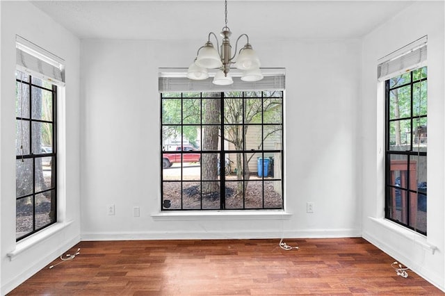 2568 Redfield Dr, Norcross, GA 30071 - unfurnished dining area with a chandelier, wood finished floors, and baseboards
