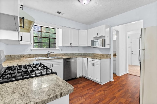 2568 Redfield Dr, Norcross, GA 30071 - kitchen featuring stainless steel appliances, white cabinets, dark wood finished floors, a sink, and a textured ceiling