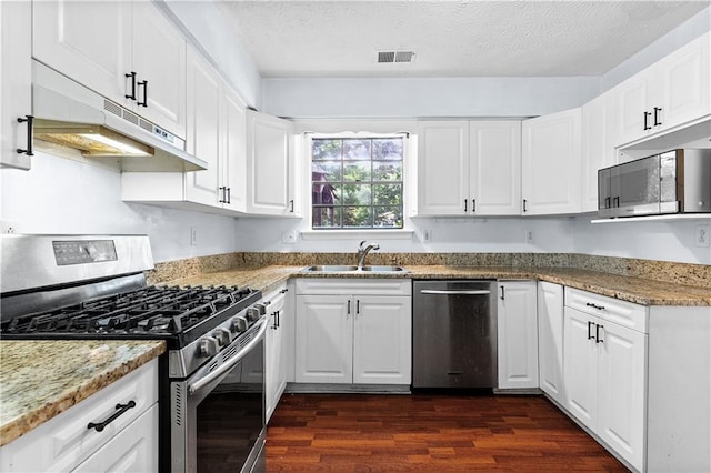 2568 Redfield Dr, Norcross, GA 30071 - kitchen featuring appliances with stainless steel finishes, a sink, dark wood-type flooring, under cabinet range hood, and white cabinets