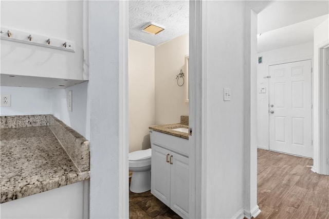 2568 Redfield Dr, Norcross, GA 30071 - bathroom featuring toilet, vanity, wood finished floors, and a textured ceiling