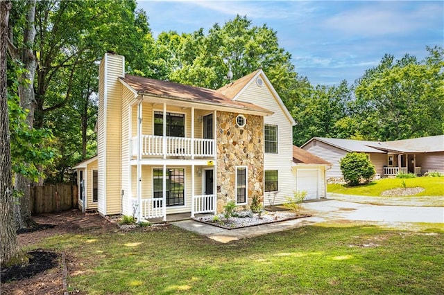 2568 Redfield Dr, Norcross, GA 30071 - view of front facade with a porch, a chimney, stone siding, a balcony, and driveway