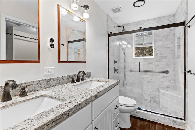 2568 Redfield Dr, Norcross, GA 30071 - full bathroom featuring toilet, double vanity, a stall shower, and wood finished floors