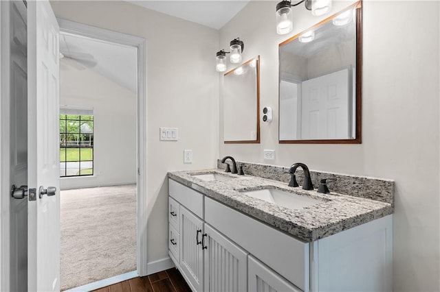 2568 Redfield Dr, Norcross, GA 30071 - bathroom featuring double vanity, wood finished floors, baseboards, and vaulted ceiling