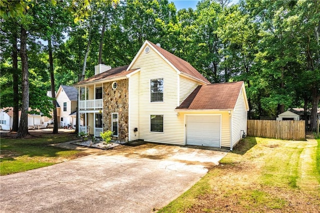 2568 Redfield Dr, Norcross, GA 30071 - traditional home featuring a balcony, driveway, stone siding, a chimney, and view of wooded area