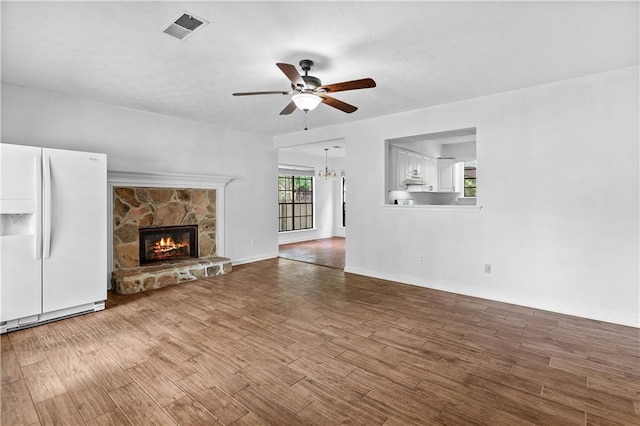 2568 Redfield Dr, Norcross, GA 30071 - unfurnished living room with ceiling fan, wood finished floors, a chandelier, and a stone fireplace