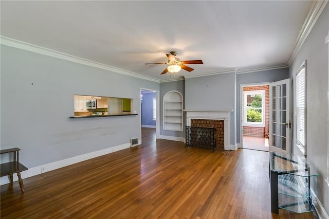 407 E College St E, Bowdon, GA 30108 - unfurnished living room with a ceiling fan, dark wood finished floors, crown molding, a fireplace, and built in shelves